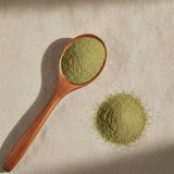 Olive Leaf Powder (Olea Europaea) | Create a luxurious, photorealistic product photograph featuring the original product naturally arranged in an elegant handcrafted wooden spoon on a soft, finely