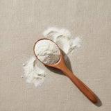 Oyster Shell Powder (Ostrea Spp.) | Create a luxurious, photorealistic product photograph featuring the original product naturally arranged in an elegant handcrafted wooden spoon on a soft, finely