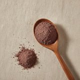 Paper Flower Powder (Bougainvillea Glabra) | Create a luxurious, photorealistic product photograph featuring the original product naturally arranged in an elegant handcrafted wooden spoon on a soft, finely