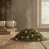 Pineapple Papaya Green Tea (Camellia Sinensis) | Can you show this tea outside of the bag and bowl, on a table next to a hot tea cup in a rustic home.
