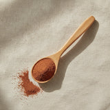 Red Clay Powder (Montmorillonite) | Create a luxurious, photorealistic product photograph featuring the original product naturally arranged in an elegant handcrafted wooden spoon on a soft, finely