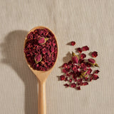Red Rose Buds & Petals Whole (Rosa Centifolia) | Create a luxurious, photorealistic product photograph featuring the original product naturally arranged in an elegant handcrafted wooden spoon on a soft, finely