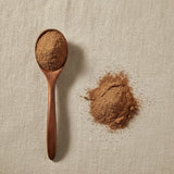 Sarsaparilla Root Powder (Mexican) (Smilax Medica) | Create a luxurious, photorealistic product photograph featuring the original product naturally arranged in an elegant handcrafted wooden spoon on a soft, finely