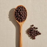 Schisandra Berry Whole (Schizandrae Chinensis) | Create a luxurious, photorealistic product photograph featuring the original product naturally arranged in an elegant handcrafted wooden spoon on a soft, finely