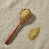 Shepherd's Purse Herb Powder (Capsella Bursa-pastoris) | Create a luxurious, photorealistic product photograph featuring the original product naturally arranged in an elegant handcrafted wooden spoon on a soft, finely
