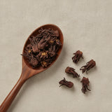 Silk Tree Flowers (Albizia Julibrissin) | Create a luxurious, photorealistic product photograph featuring the original product naturally arranged in an elegant handcrafted wooden spoon on a soft, finely