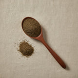 Spikemoss Powder (Selaginella Involvens) | Create a luxurious, photorealistic product photograph featuring the original product naturally arranged in an elegant handcrafted wooden spoon on a soft, finely