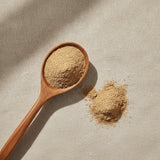Suma Powder (Pfaffia Glomerata) | Create a luxurious, photorealistic product photograph featuring the original product naturally arranged in an elegant handcrafted wooden spoon on a soft, finely