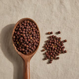 Szechuan Pepper Whole (Zanthoxylum Simulans) | Create a luxurious, photorealistic product photograph featuring the original product naturally arranged in an elegant handcrafted wooden spoon on a soft, finely