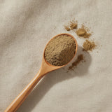 Turkey Tail Mushroom Powder (Trametes Versicolor) | Create a luxurious, photorealistic product photograph featuring the original product naturally arranged in an elegant handcrafted wooden spoon on a soft, finely