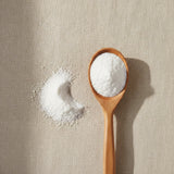 Vitamin C Powder (Ascorbic Acid) | Create a luxurious, photorealistic product photograph featuring the original product naturally arranged in an elegant handcrafted wooden spoon on a soft, finely