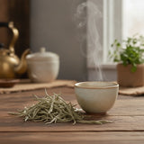 White Tea (Camellia Sinensis) | Can you show this tea outside of the bag and bowl, on a table next to a hot tea cup in a rustic home.